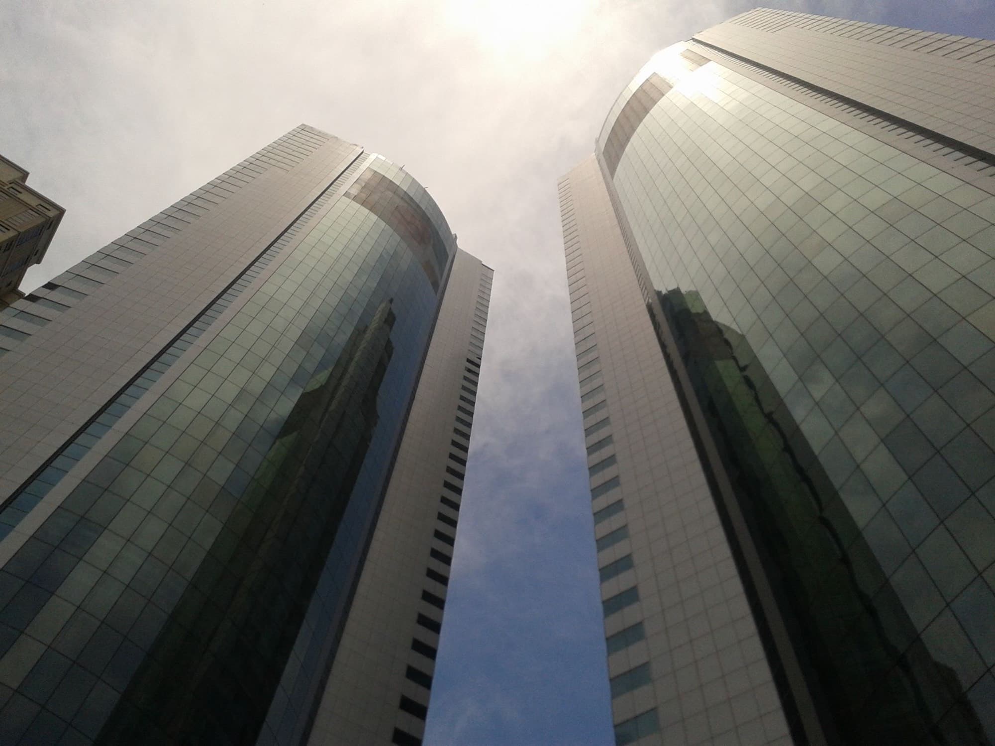 Modern glass office towers in Dubai rising into a bright sky